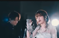 Live performance still with a singer at a microphone